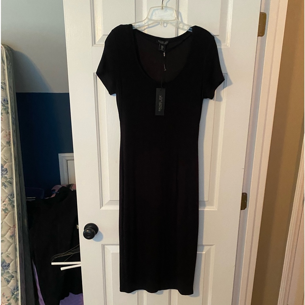 Black ribbed knit dress. Lined to knee. Slit in the back. New with tags